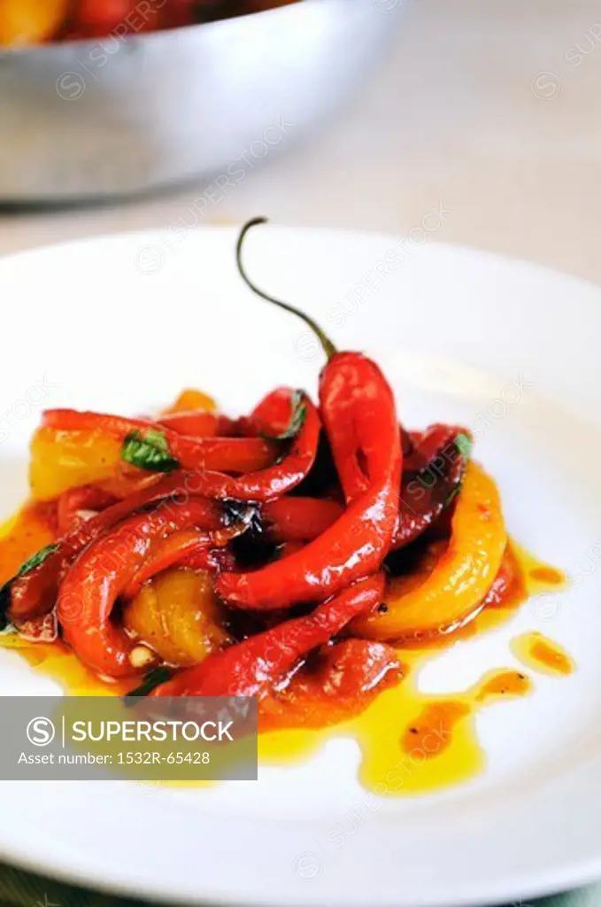 A plate of pan cooked sweet red and yellow peppers with fresh chilies and sun dried tomatoes