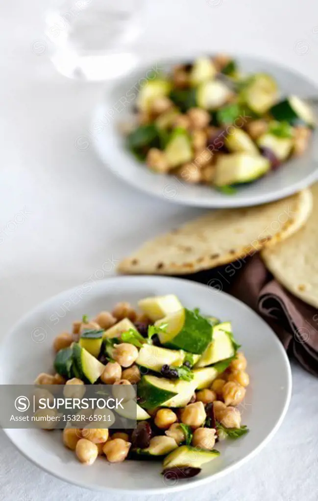 Plates of Chickpea and Zucchini Salad with Pita Breads