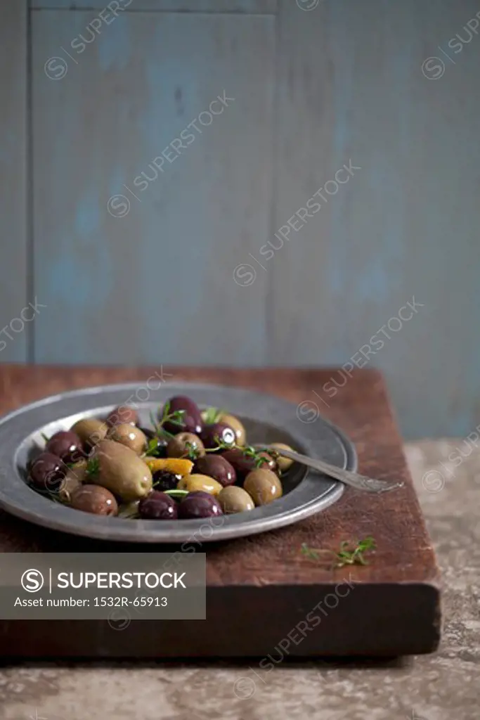 Mixed Marinated Olives with Thyme on a Metal Plate