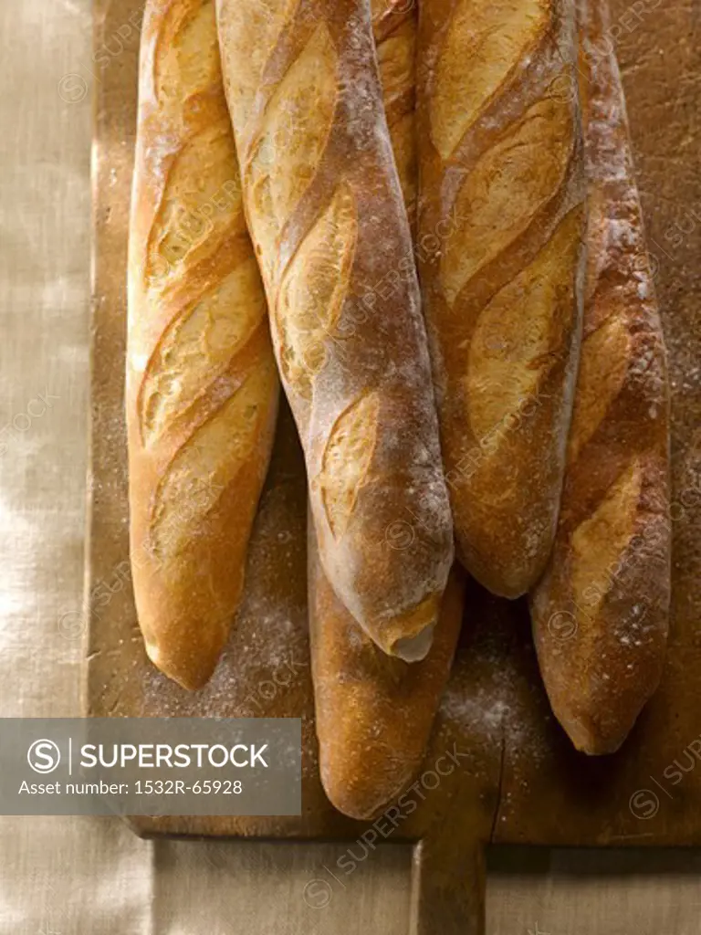 Five Baguettes on a Wooden Cutting Board Sprinkled with Flour
