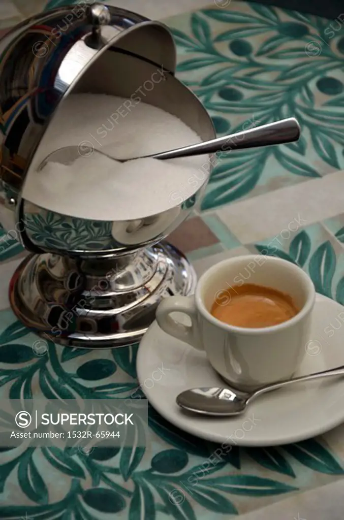 An espresso and a sugar pot