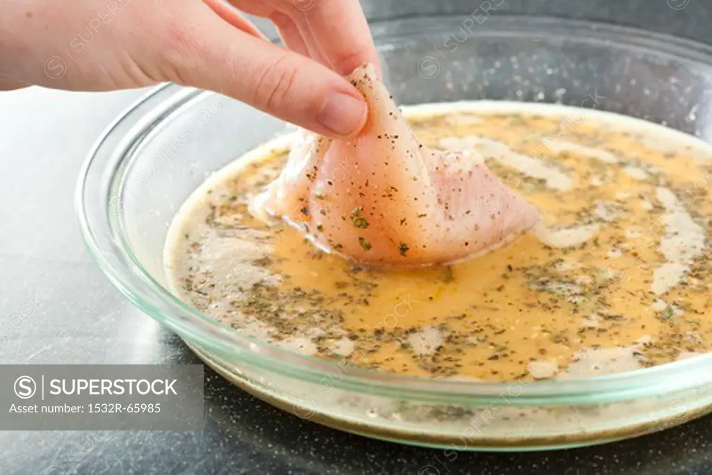 Dipping Chicken in Seasoned Egg; Step in Making Crunchy Baked Chicken