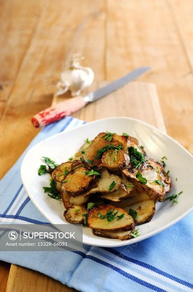Fried Jerusalem artichoke slices with garlic and parsley