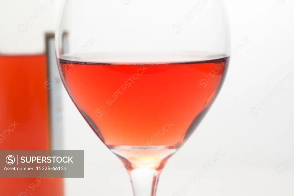 Glass of White Zinfandel Wine with Bottle in Background