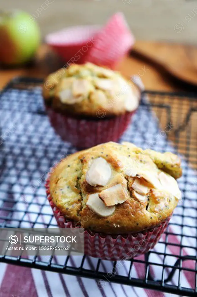 Apple muffins with poppy seeds and almonds on a wire rack
