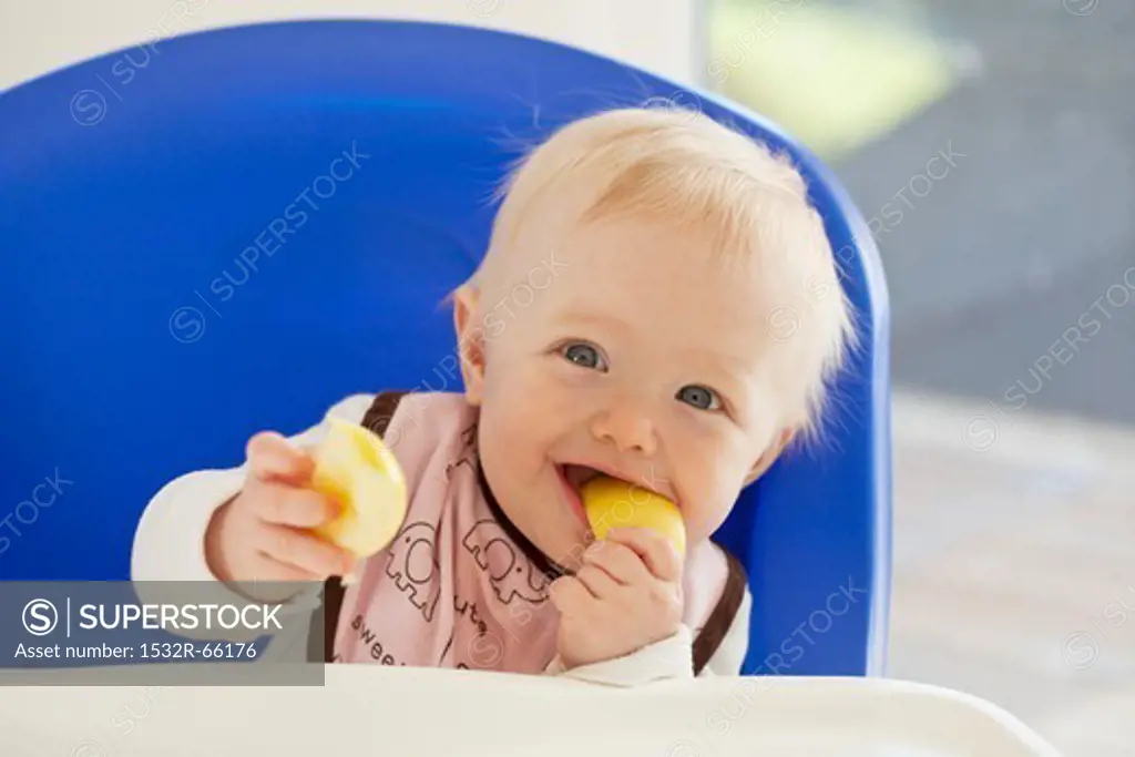 A baby eating an apple