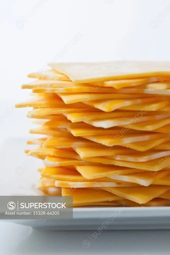 Stack of yellow American and Colby jack cheese on a white plate