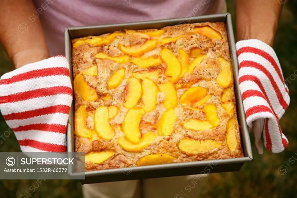 Woman Holding Fresh From the Oven Peach Cobbler