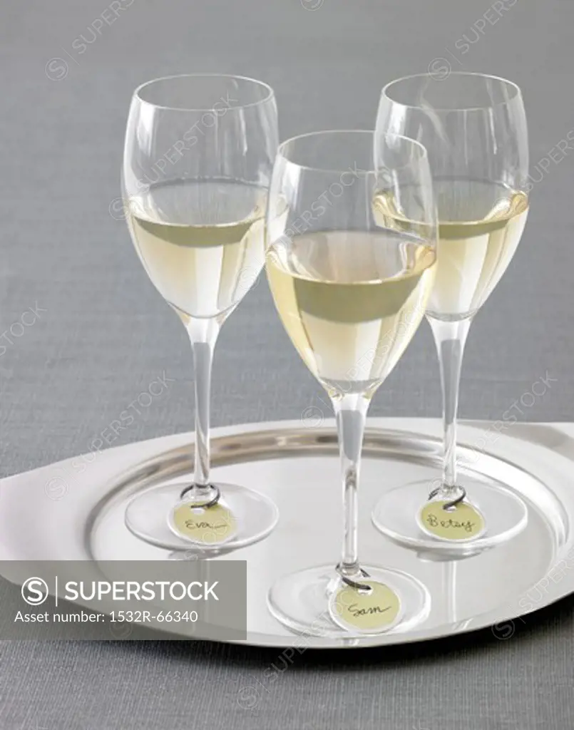 Three Glasses of White Wine with Name Tags on a Silver Tray