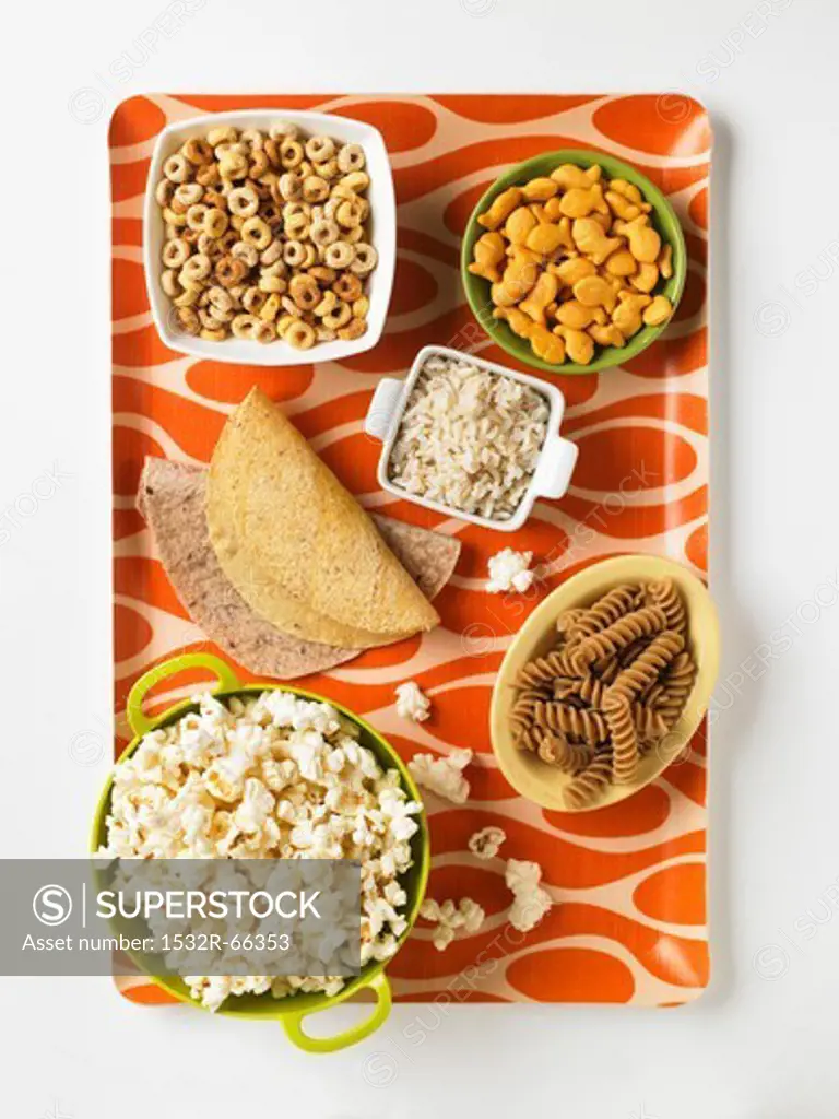 Assorted Grain Based Products: Taco Shells, Tortillas, Whole Grain Fusilli, Popcorn, Rice, Cereal and Goldfish Crackers