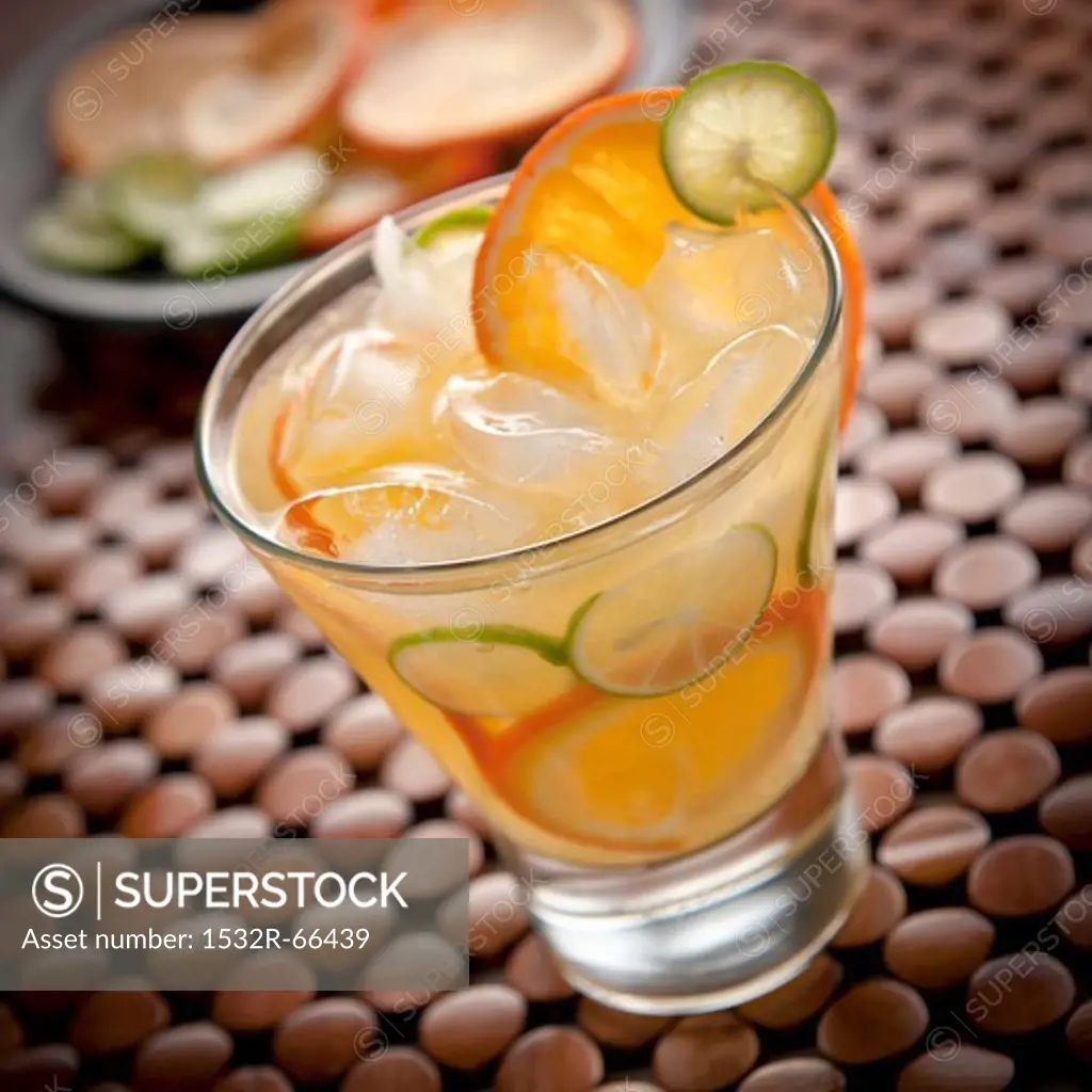 Citrus Vodka Cocktail with Lime and Orange Slices in a Glass with Ice