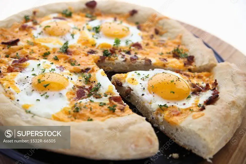 Breakfast Pizza with Egg, Cheese and Bacon; One Slice Partially Removed