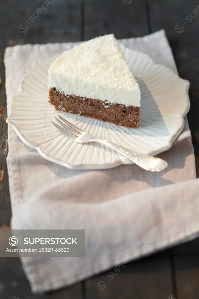 A piece of poppy seed cake topped with coconut mousse