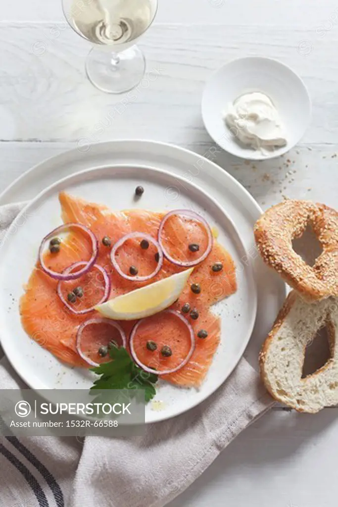 Smoked salmon with capers and onions served with a sesame seed bagel and crème fraîche