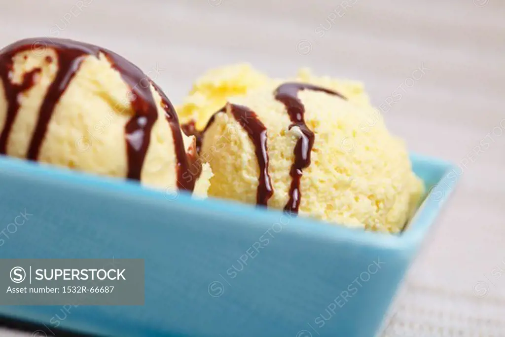 A few scoops of home-made vanilla ice cream with chocolate sauce in a bowl