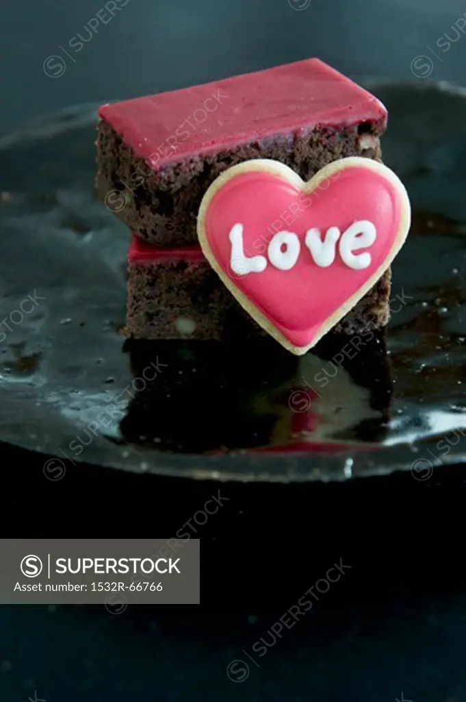 Brownies with red icing and a heart-shaped biscuit