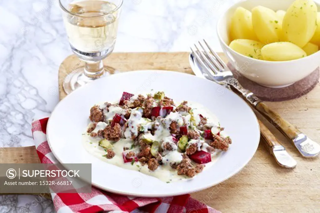 A dish of beetroot and minced meat served with boiled potatoes