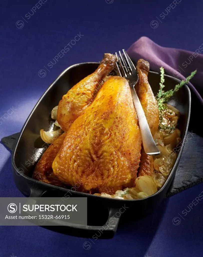 Roasted guinea fowl with onions in the roasting tin