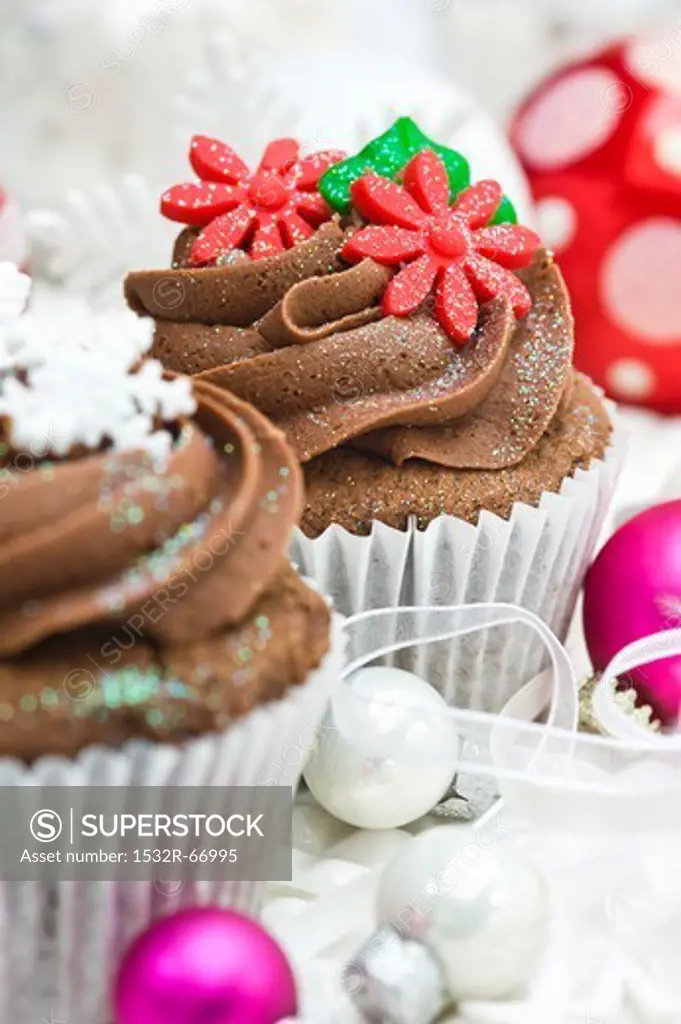 Chocolate cupcakes decorated with sugar flowers and snow flakes for Christmas