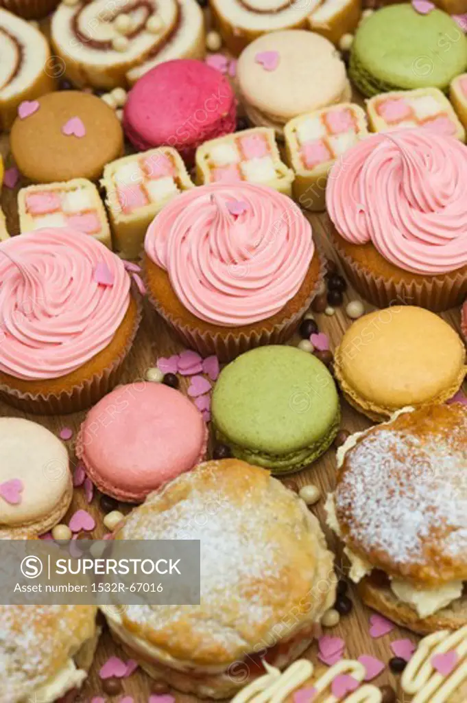 Rows of cupcakes, scones, macarons, Swiss rolls and pieces of mini Battenburg cake