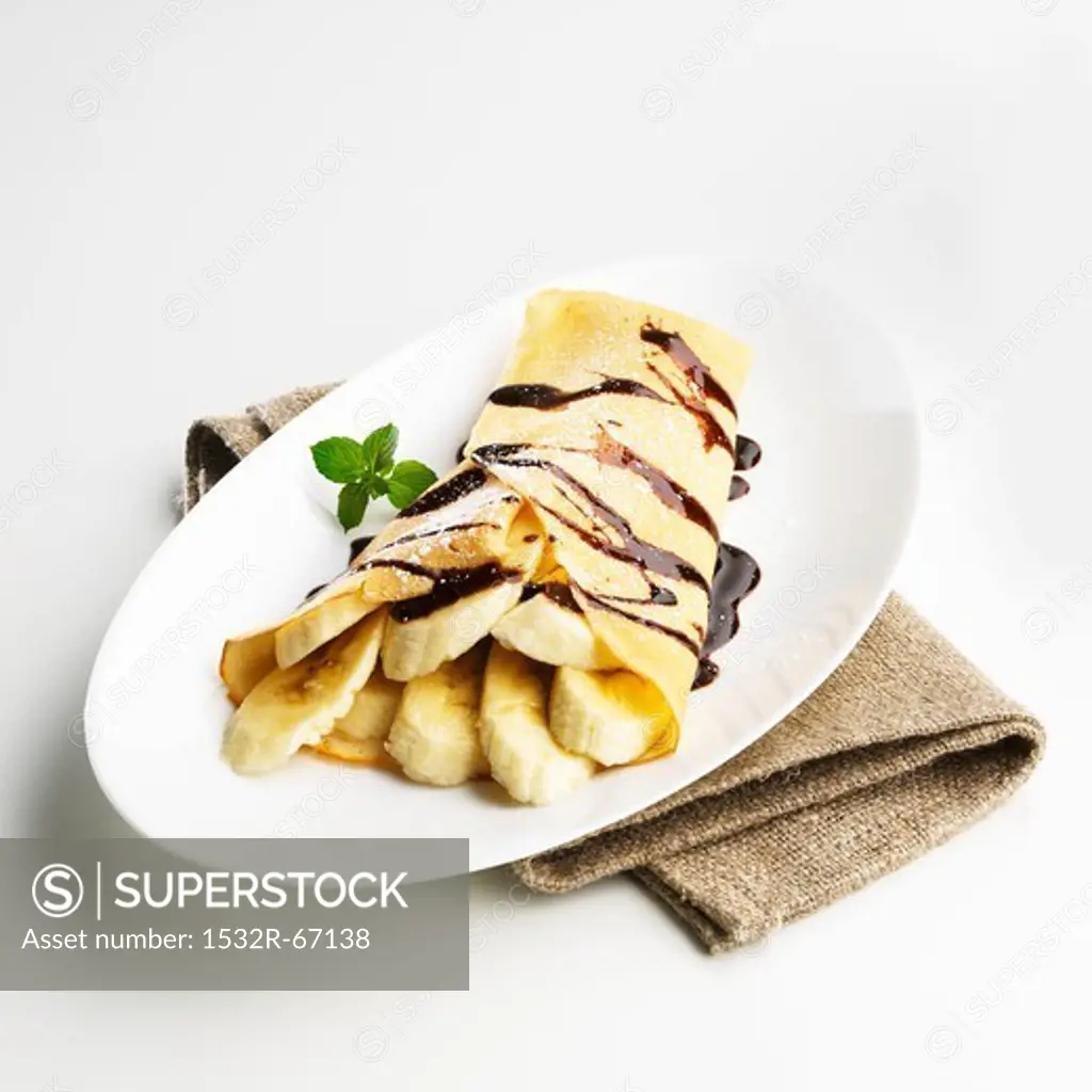 Crepe with banana slices and chocolate sacue