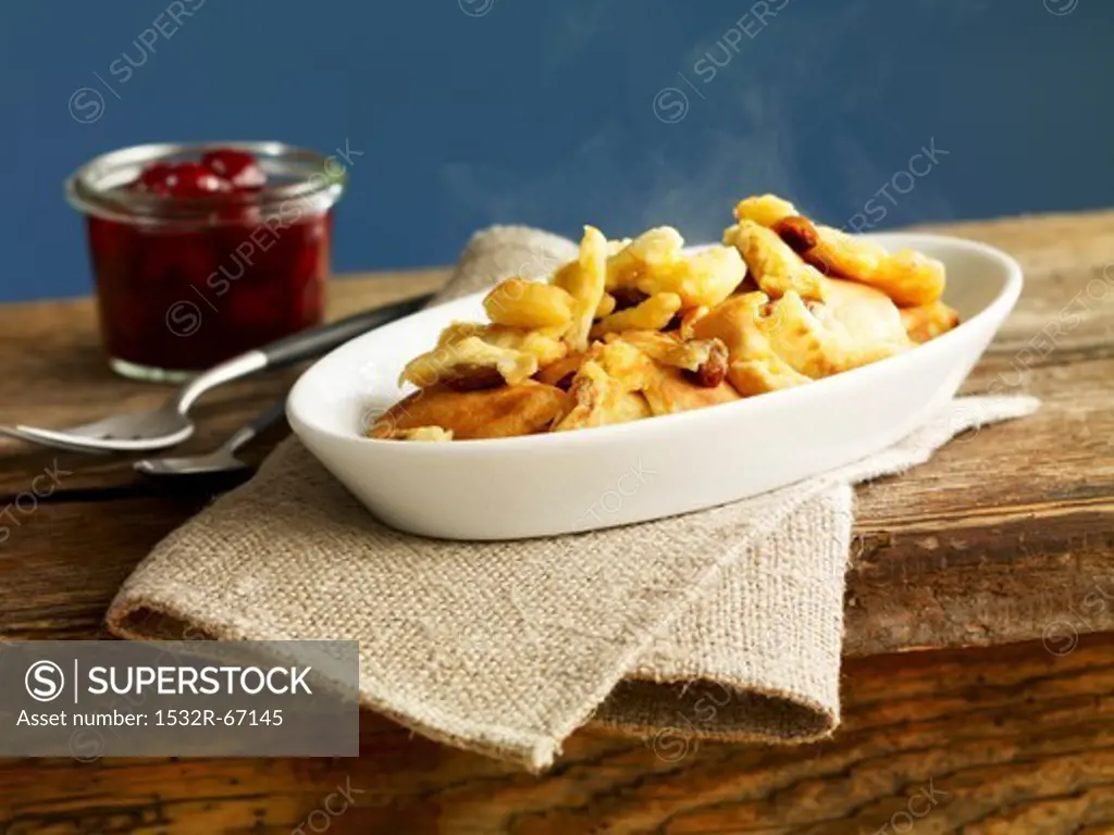Kaiserschmarren (sweet cut up pancakes) in a casserole dish with cherry compote