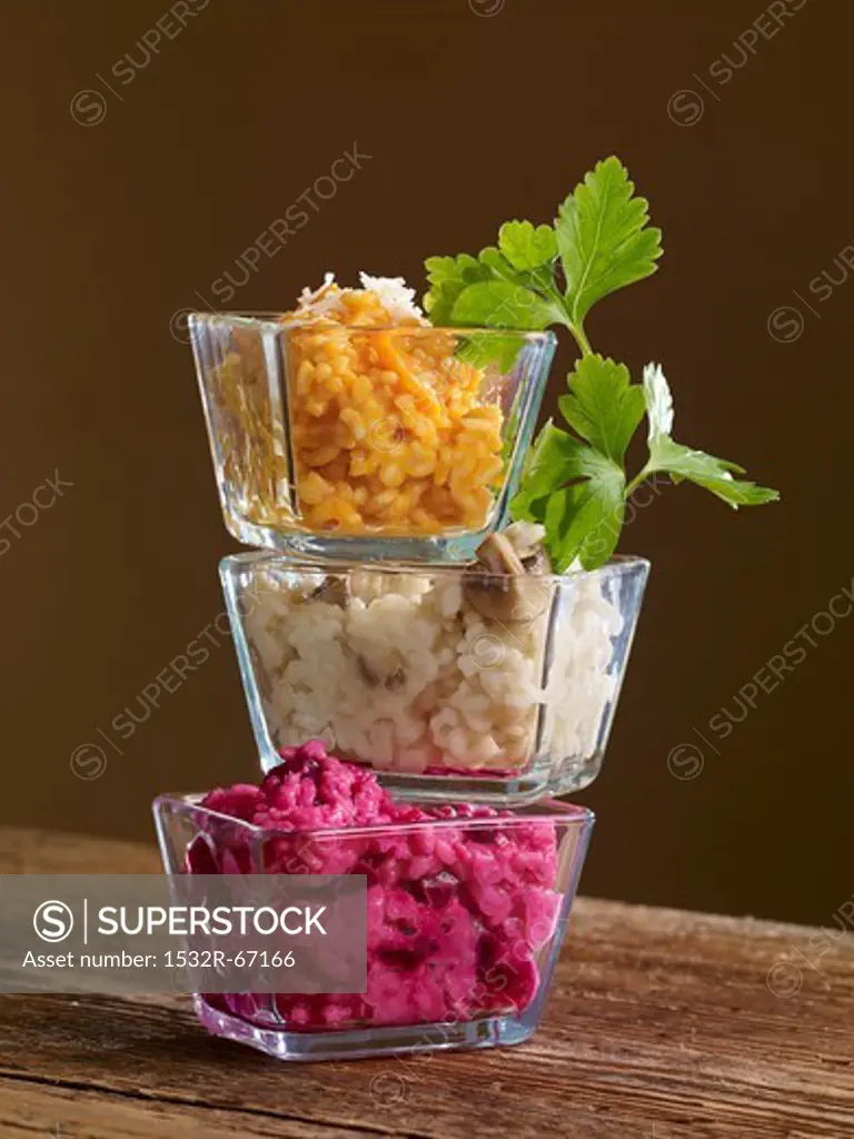 Three types of risotto in glass bowls stacked on top of one another
