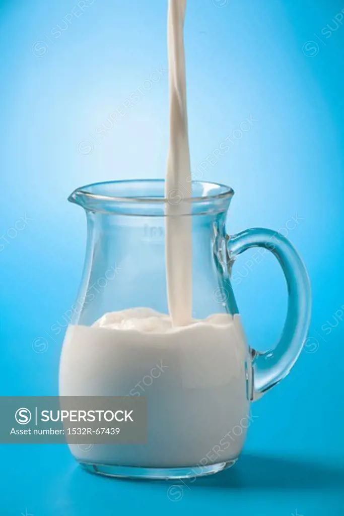Pouring milk into a glass jug