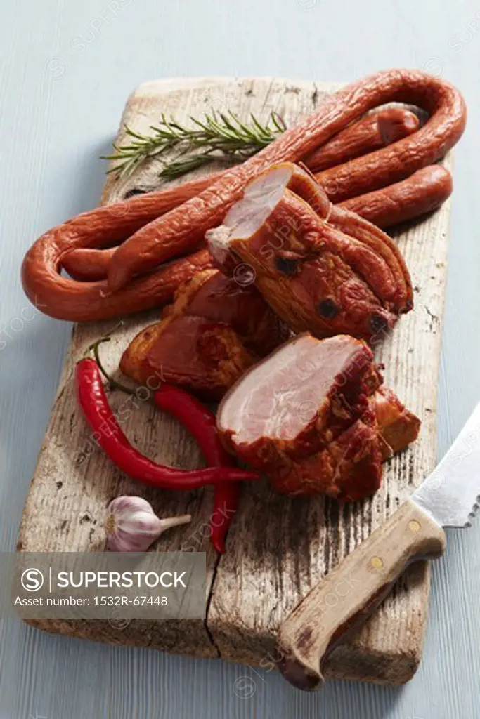 Smoked meat and sausages on a wooden cutting board
