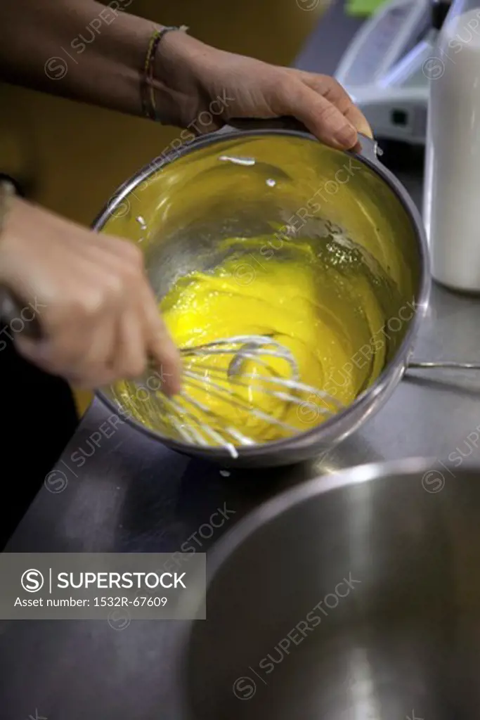 The egg yolk and sugar being whisked together