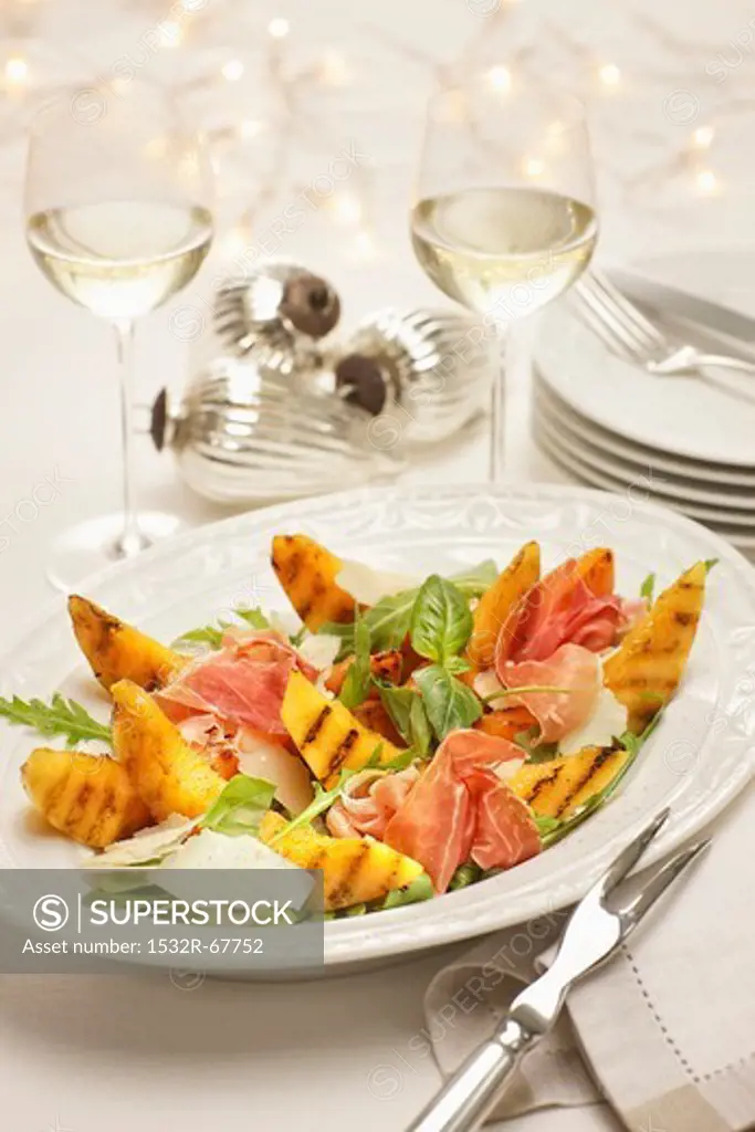 Grilled melon with prosciutto on rocket and parmesan salad at Christmastime