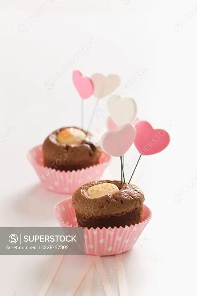 Miniature chocolate cakes topped with heart-shaped decorations