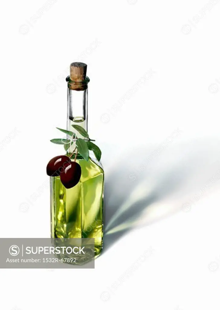 An olive oil bottle with black olives