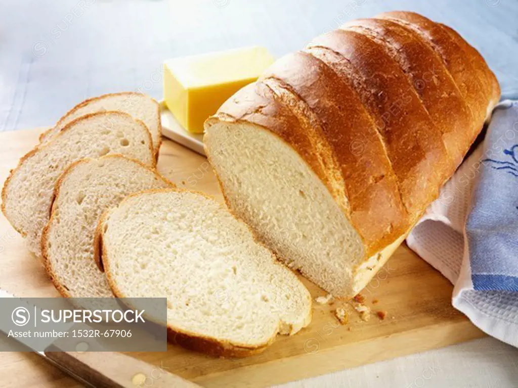 A white loaf, baked in a tin, with some cut slices