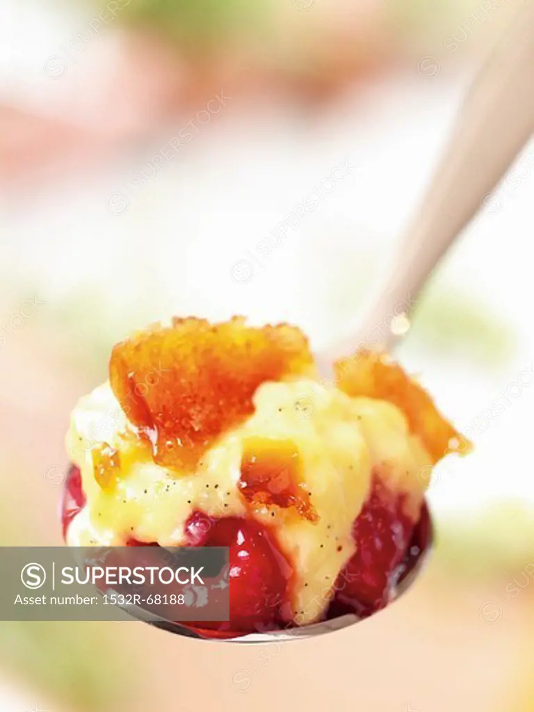 A spoonful of crème brûlee with raspberries (close-up)