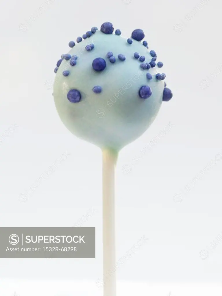 A cake pop with blue glaze and sugar pearls