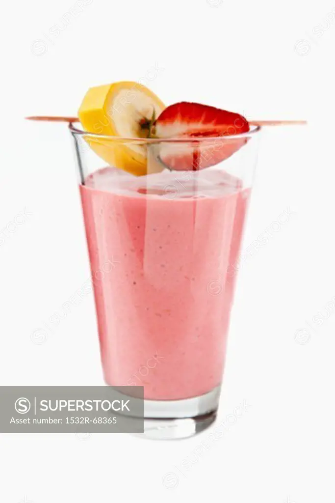 A strawberry smoothie with banana and strawberry pieces on a cocktail stick