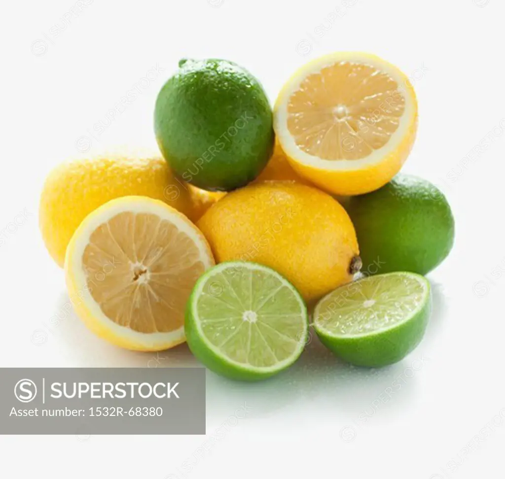 A pile of limes and lemons, whole and halved