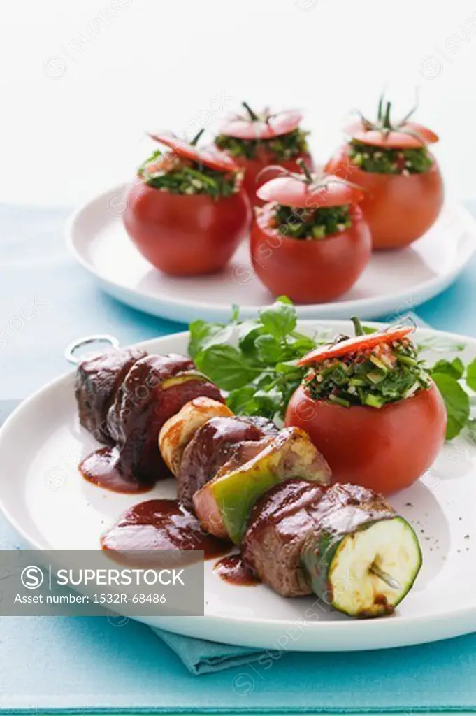 Beef skewers with vegetables and halloumi, and tomatoes stuffed with tabbouleh