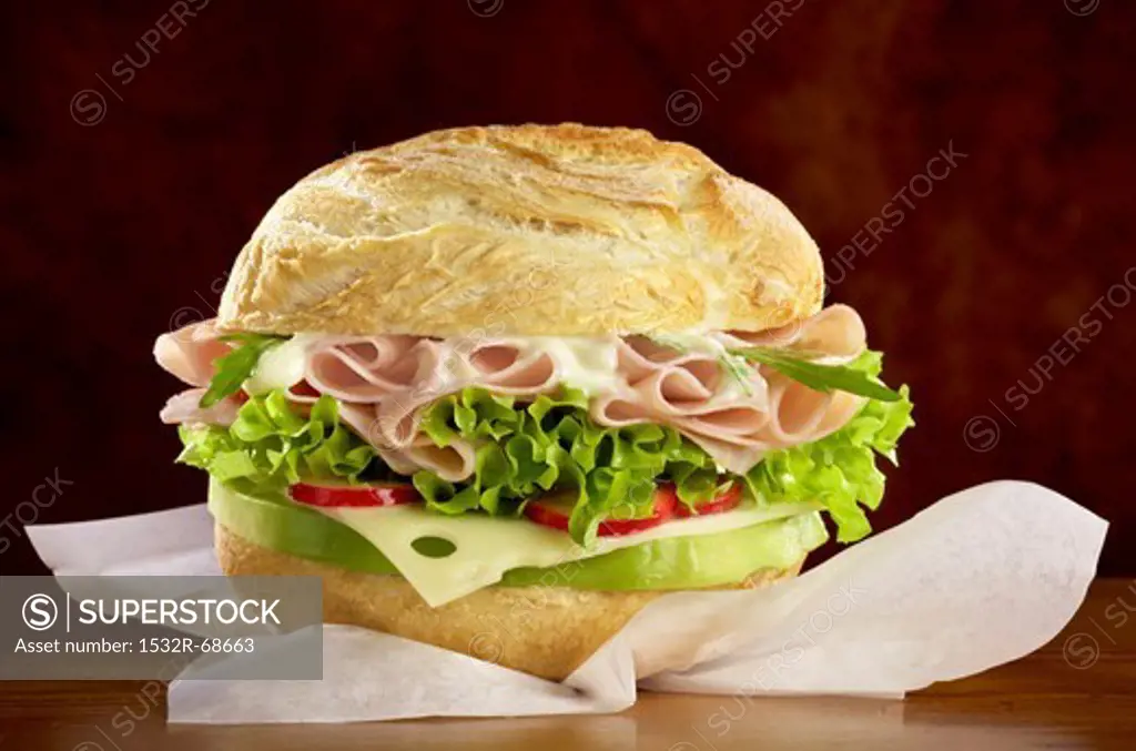 A roll filled with cheese, ham and salad
