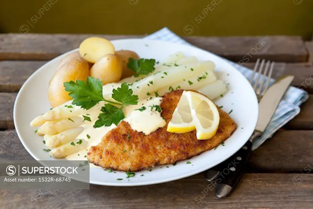 White asparagus and a schnitzel with Hollandaise sauce and potatoes