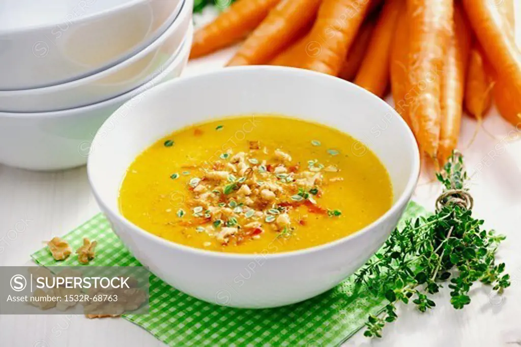 Celery and carrot soup garnished with fried celery, bell pepper, walnuts and thyme; selective focus