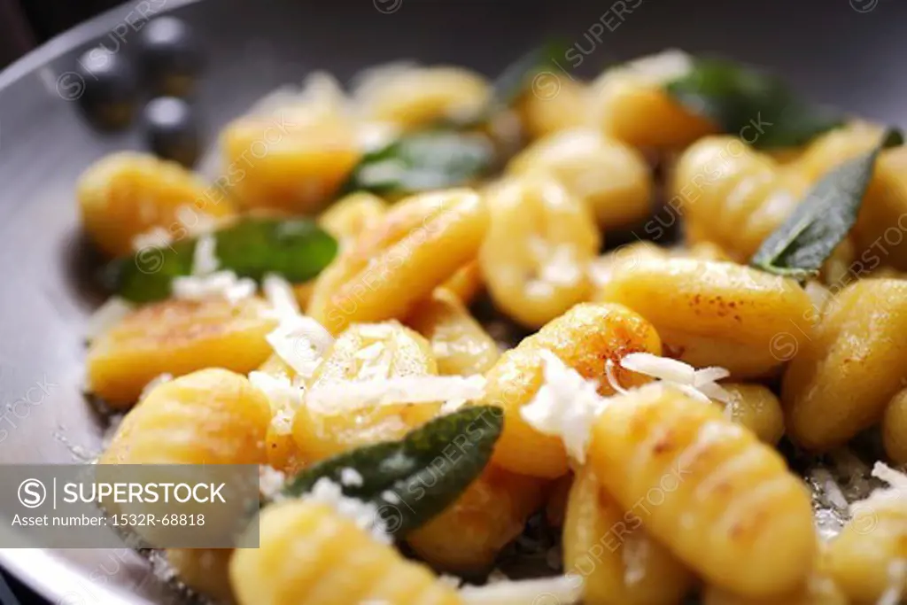 Gnocchi with sage and parmesan in a frying pan (close-up)