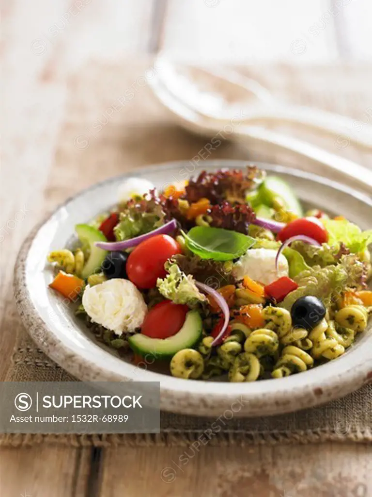 Pasta salad with pesto, tomatoes, olives and mozzarell