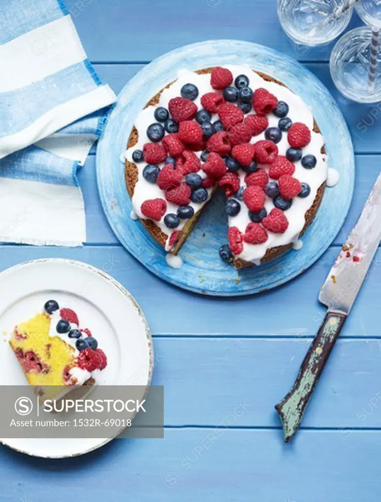 Berry cake with sugar icing, one slice cut