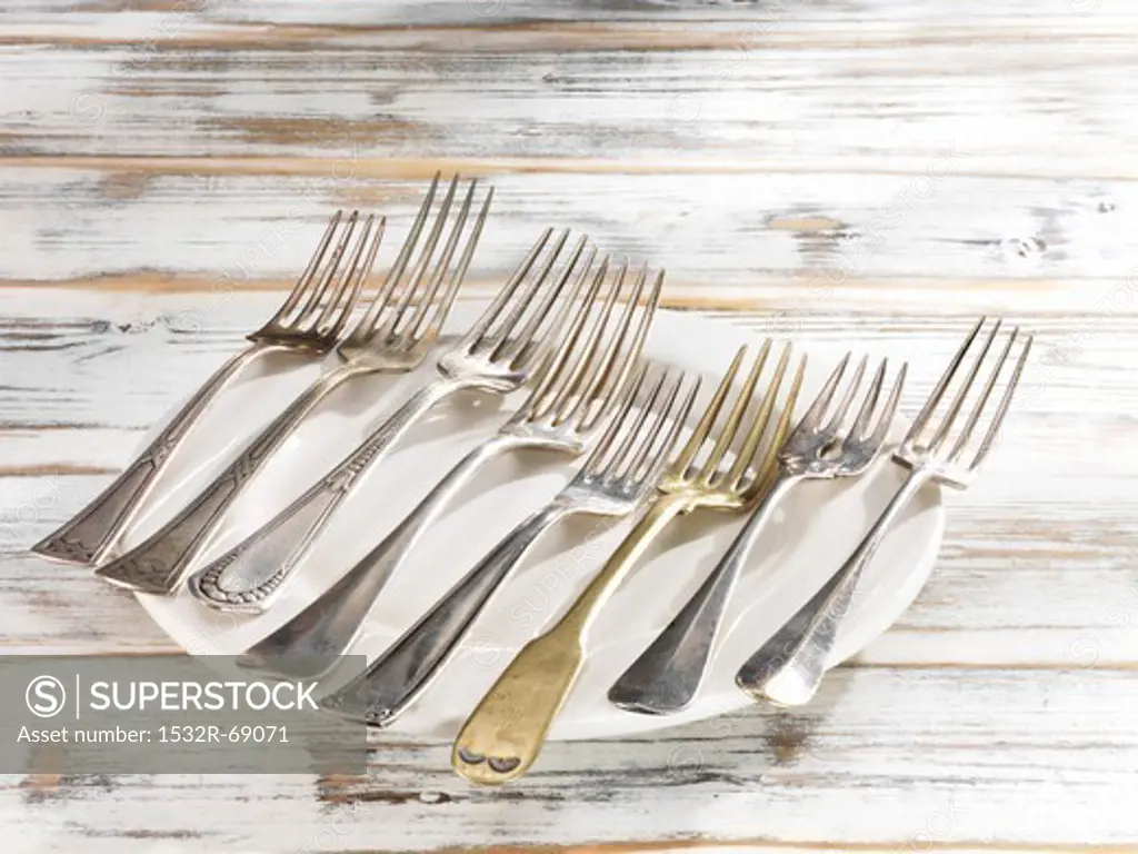 Eight forks in a line lying on a plate