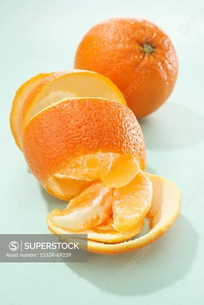 A whole orange, orange peel and orange segments