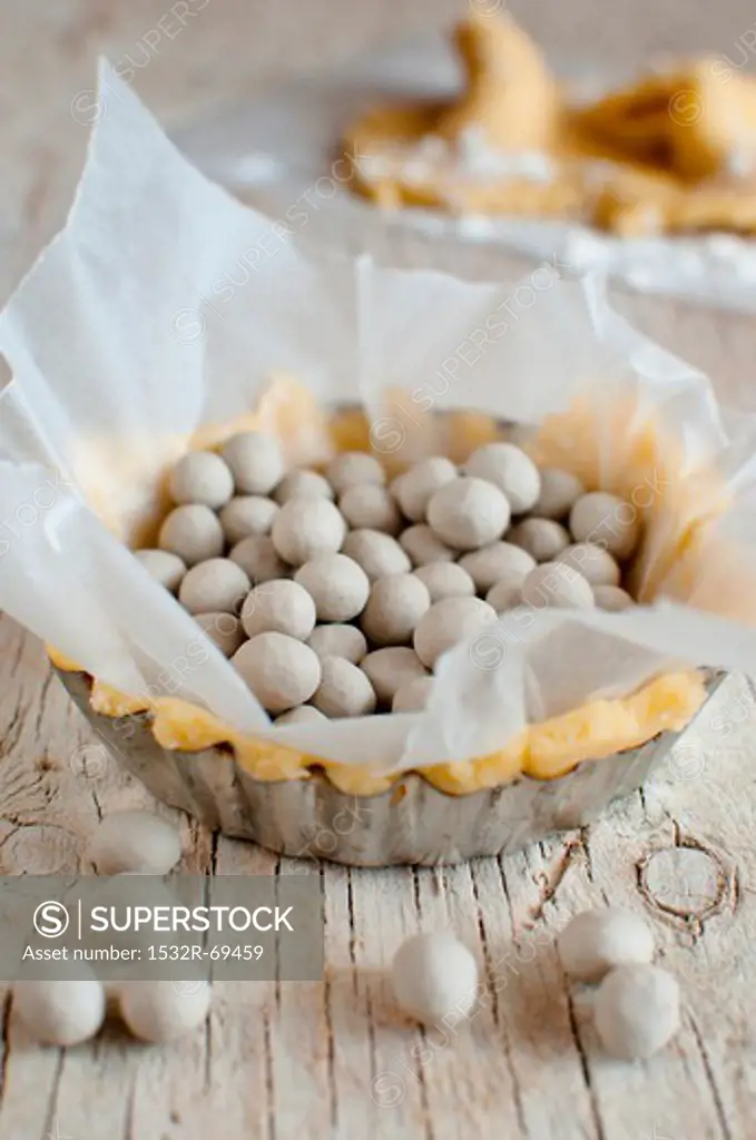 An individual tart case filled with soya beans for blind baking