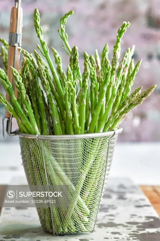 Green asparagus in a deep-frying basket