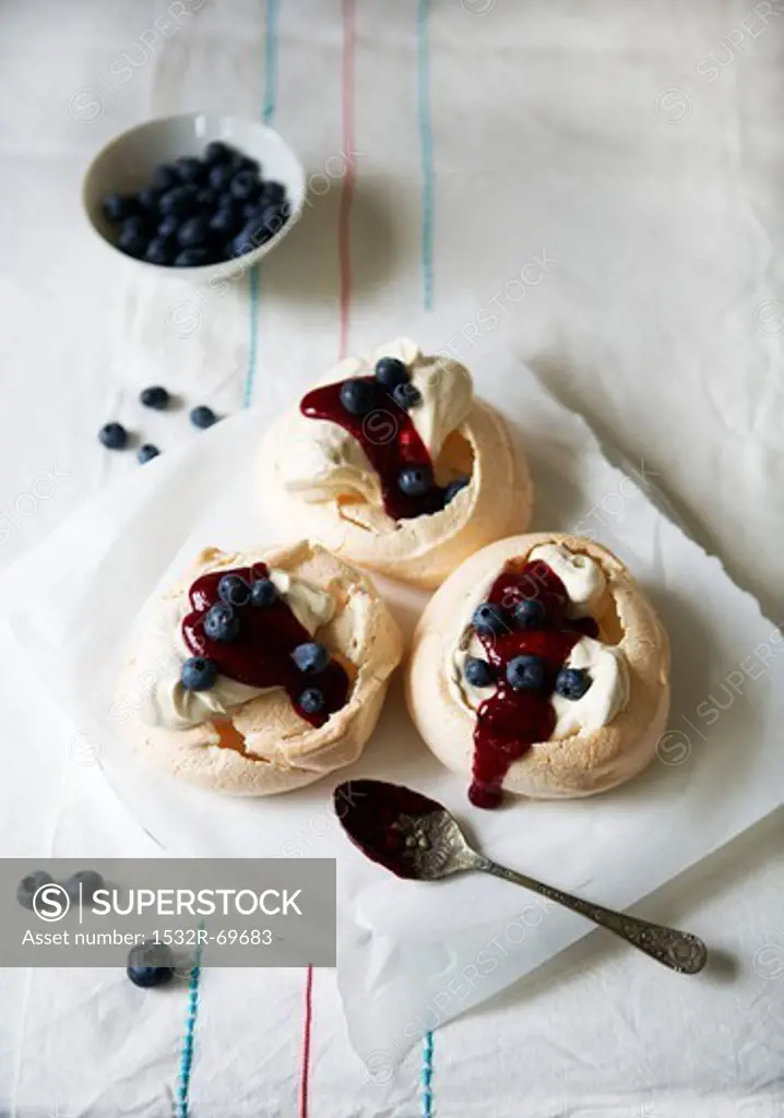 Meringue nests with cream and blueberry sauce